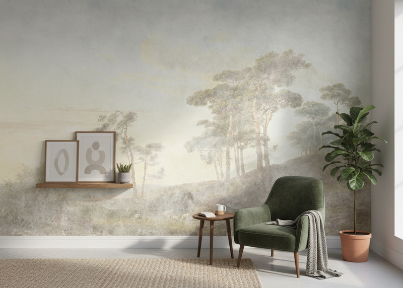 Modern interior with a green armchair, side table, and wall mural of trees.