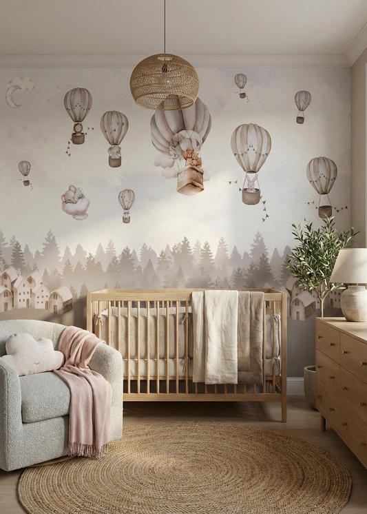 Nursery room with wooden crib, armchair, and decorative wall mural of hot air balloons and trees.