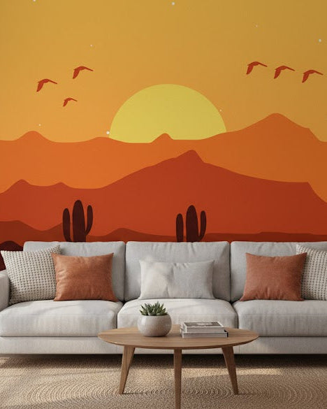 Living room with a gray sofa against a desert-themed wall mural featuring a sunset and cacti.