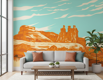 Living room with a couch, coffee table, and wall mural of desert landscape.